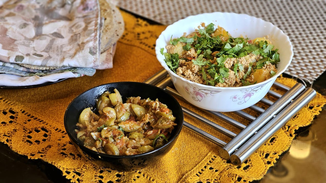 about-01 Authentic Indian dishes including chapati, vegetable curry, and chutney served on a table.