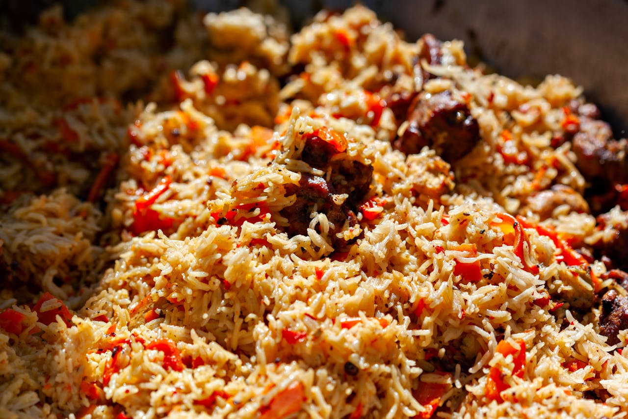 services-04 Mouthwatering close-up of a delicious biryani dish with spices and tomatoes.